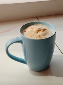 A mug of hot coffee with a thick foam on top