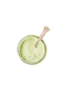 A glass jar of smooth pale-green cashew and coriander paste